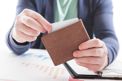 Men in suit with wallet and credit card. Selective focus of credit card in brown leather wallet. Business documents on office table  and  with social network diagram as Online shopping concept