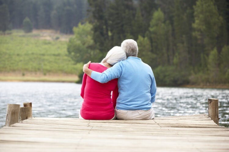 Senior couple sitting on a jetty